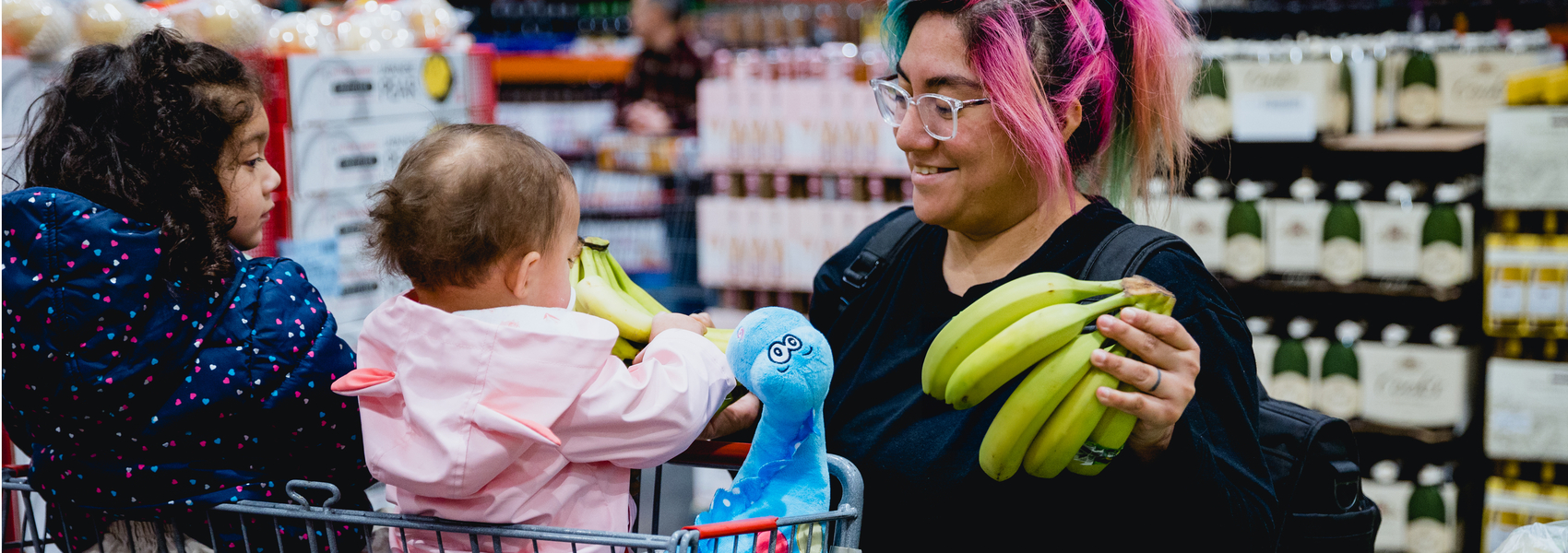 A foster mom is grocery shopping with young children